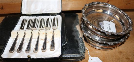 Pair of plated bottle coasters, mother of pearl-handled fruit eaters & two other flatware sets, all cased